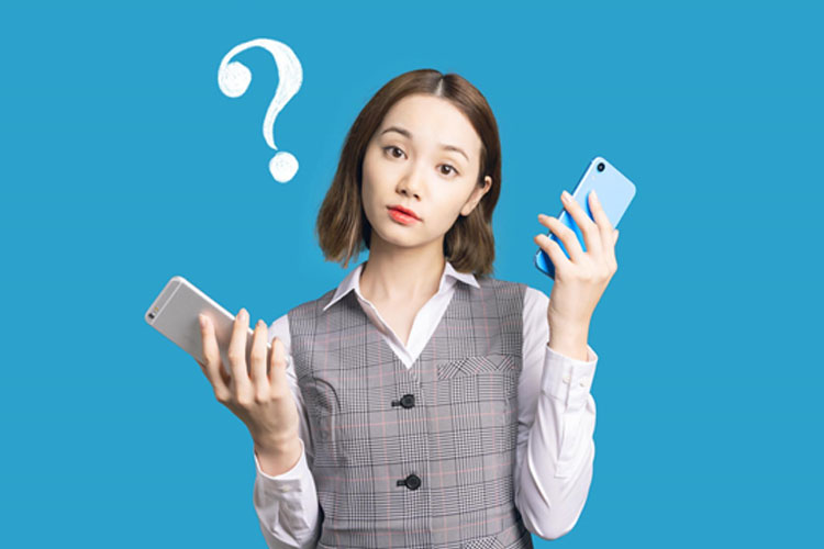 バッテリー消耗ぎみのiPhoneを手に持って悩んでいる女性