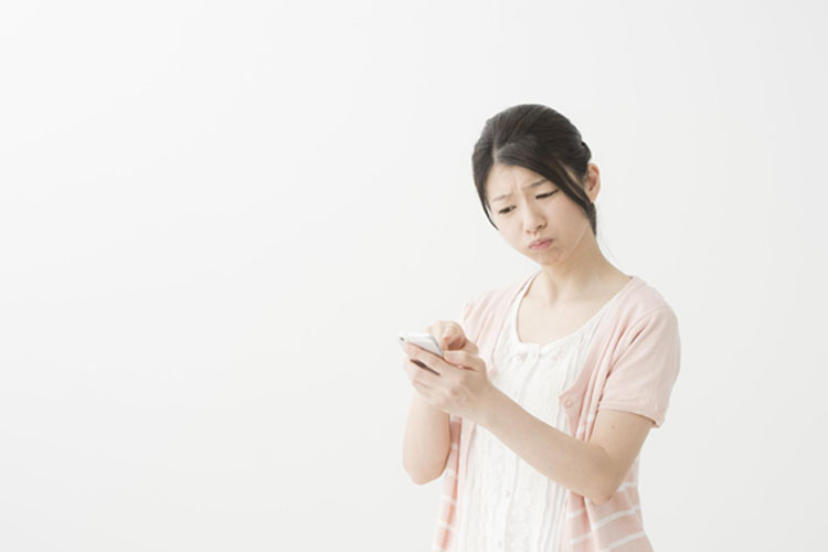 iPhoneを手に困っている女性