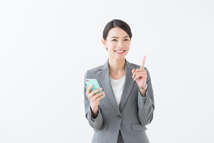 iPhoneを手荷物スーツの女性